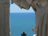 A statuary in the extreme foreground with the sea in the deep background.