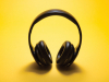 A pair of headphone photographed against a yellow background