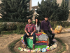 Three students pose on the painted rocks in the garden at Kashkul