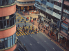 A shot from above as a throng of people cross a city street