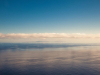 A placid see white clouds and sunset lighting