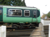 Green train passing platform outside