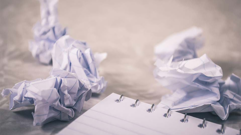 Pieces of paper wadded up next to a pad