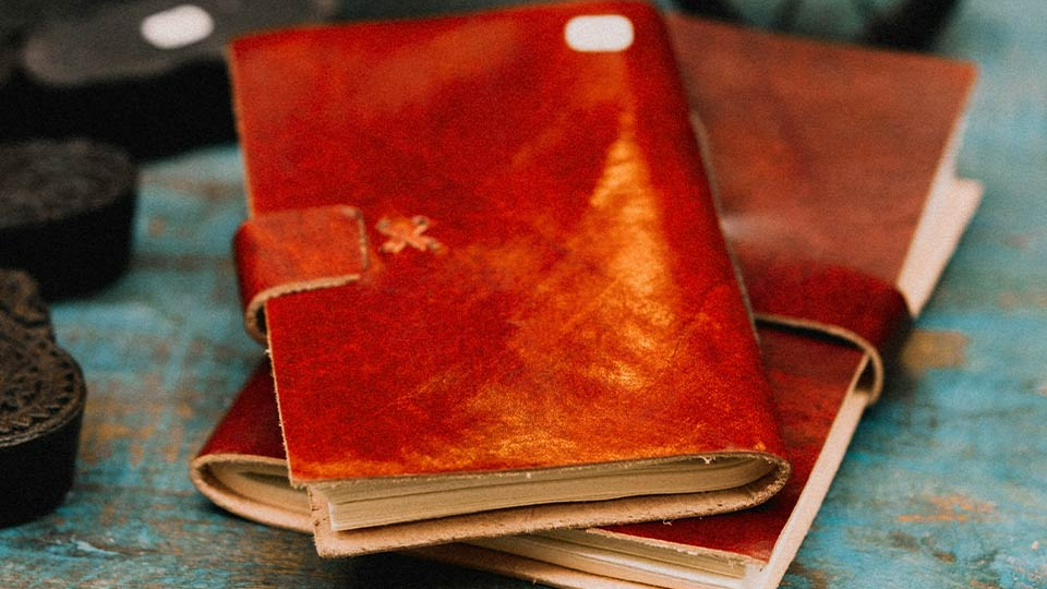 A photograph of two leather bound journals in a pile