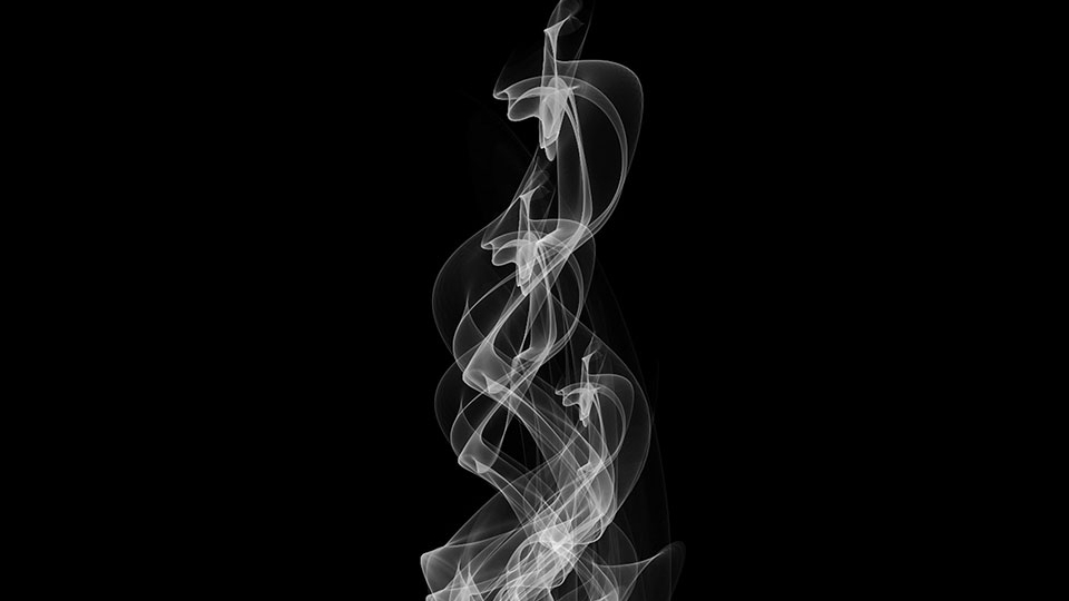 A black and white photo of time-exposed lights in darkness