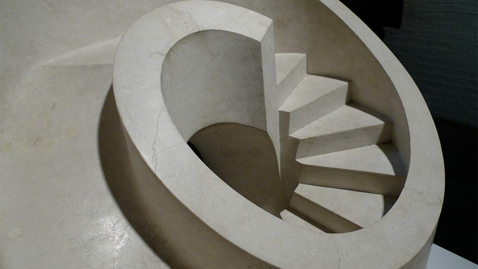 A sculpture from above of a curved staircase that leads down to nowhere