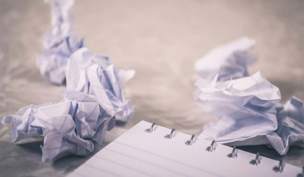 Pieces of paper wadded up next to a pad