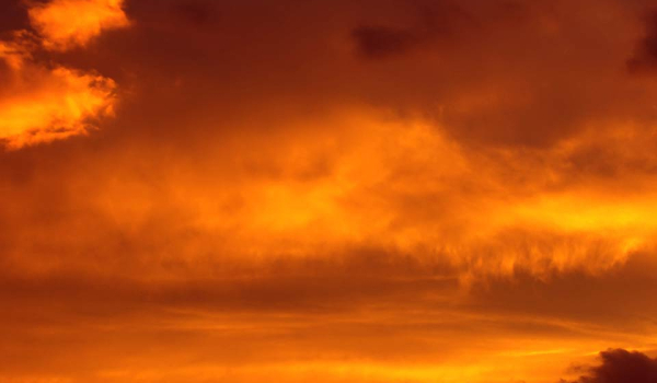 A sky at sunset, a thin blanket of orange clouds lightly covering it