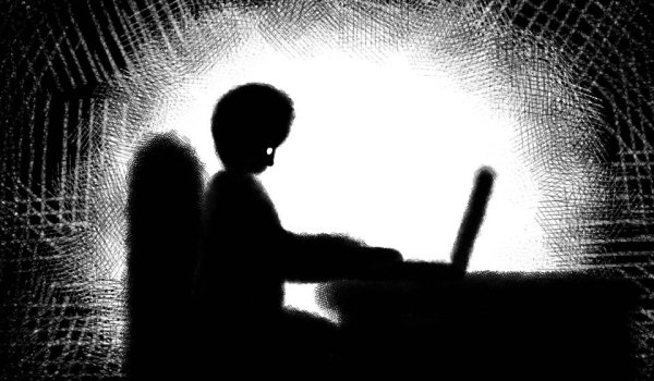 An illustration of a figure in shadow typing on a computer