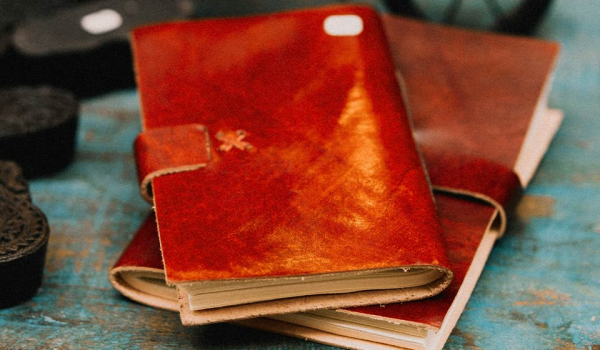 A photograph of two leather bound journals in a pile