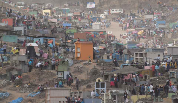 An aerial shot of a chaotic scene of hundreds of families holding simultaneously holding funerals in a massive open area