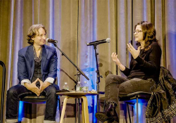The interviewer and interviewee talk together on a stage