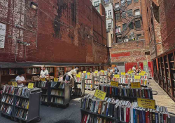 Racks of books on sale outdoors in a city alleyway