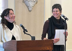 Guadalupe Nettel stands at the lectern laughing while Rosalind Harvey watches her, smiling