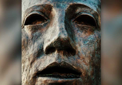 A close up of a human face in bronze