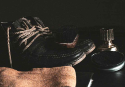 A shoe polish kit sits by a pair of leather shoes
