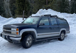 A photograph of a Chevy Suburban covered in snow