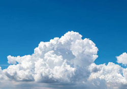 A blue sky filling with puffy clouds from the bottom