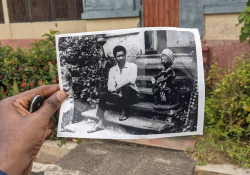 A photograph of a person holding a photograph of Wolé Soyinka