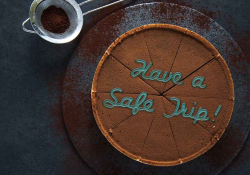 A chocolate pie with the words Have a Safe Trip written on it in frosting