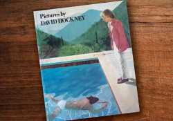 A photograph of David Hockney's book Photos laying on a wood grain table
