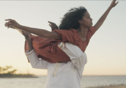 A photograph of a man holding a woman above his head