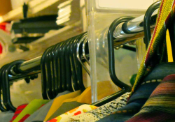 A close-cropped shot of a row of costumes on hangers in a long row. The focus is on the hangers.