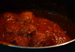 A photograph of meatballs in tomato sauc