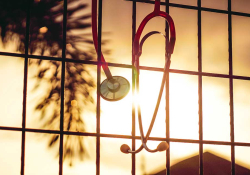 A photograph of a stethoscope hanging into a window through which the sun is shining