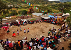 A bird's eye view of a small crowd watching dancers in bright clothing