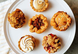 A photograph of six pastries on a white serving platter from above