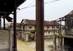 Decrepit buildings stand in an abandoned prison