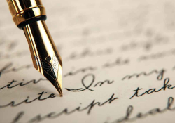 A photograph of a fountain pen writing in cursive on paper