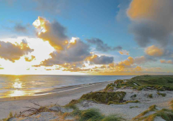 A photograph of a sandy beach and adjoining shoreline