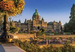 A photograph of. Parliament building, Victoria, BC; with inner harbor summer activities underway all around